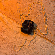 Bolso con charm de charol y perlas