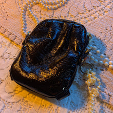 Bolso con charm de charol y perlas
