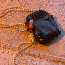 Bolso con charm de charol y perlas