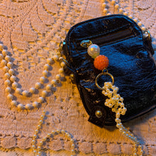 Bolso con charm de charol y perlas